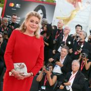 Catherine Deneuve con un sorriso radioso riceve il suo premio alla Mostra del Cinema