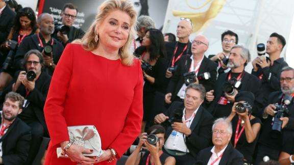 Catherine Deneuve con un sorriso radioso riceve il suo premio alla Mostra del Cinema