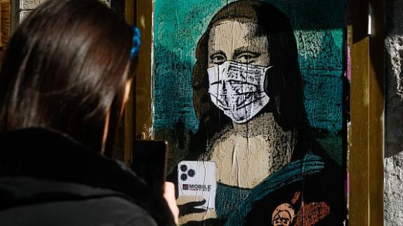 Il Coronavirus diventa arte: uno street artist dipinge la Gioconda con mascherina e smartphone